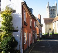 Row of pretty cottages with church with tower in the background.