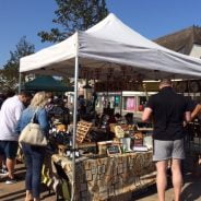 People browsing a market stall selling antiques