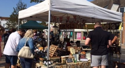 People browsing a market stall selling antiques