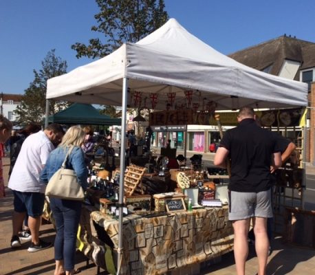 People browsing a market stall selling antiques