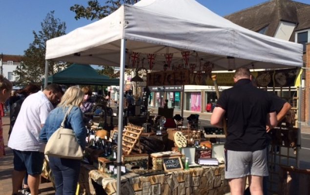 People browsing a market stall selling antiques