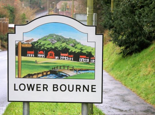 A village entry sign for Lower Bourne