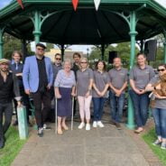 A group of people standing in front of a bandstand.