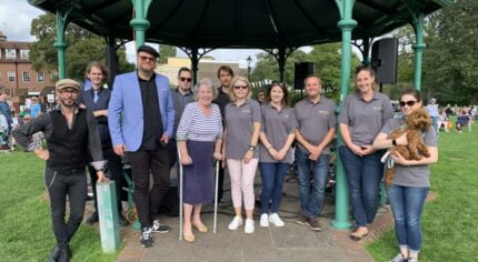 A group of people standing in front of a bandstand.