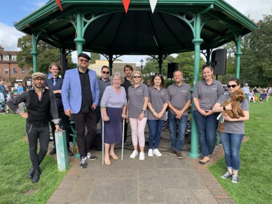 A group of people standing in front of a bandstand.