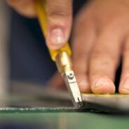 Close up of a hand cutting glass.