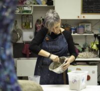 Lady with short grey hair mixing a bowl.