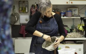 Lady with short grey hair mixing a bowl.