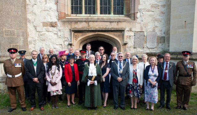 Group of people in formal dress standing outside a church