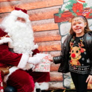 Father Christmas handing a gift to a young girl