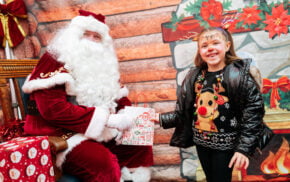 Father Christmas handing a gift to a young girl
