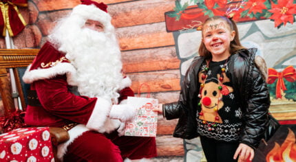 Father Christmas handing a gift to a young girl