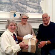 Female presents a gift to a couple.