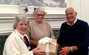 Female presents a gift to a couple.