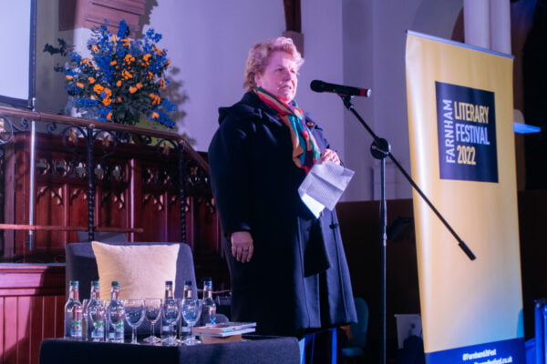 Female on stage speaking into a microphone