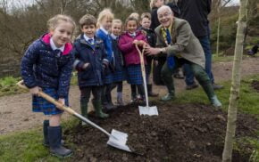 Small group of schoolchildren planting a tree with the Mayor