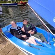 Two people in a blue sailing boat