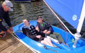 Two people in a blue sailing boat