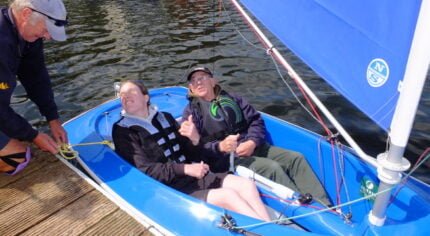 Two people in a blue sailing boat