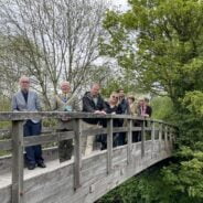 Group of people standing on a wooden bridge