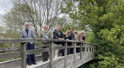 Group of people standing on a wooden bridge