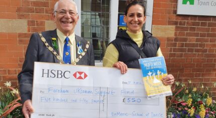 Male and female holding a large cheque