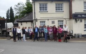 Group of walkers standing in front of a white building.