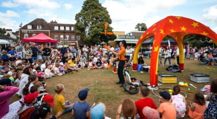 Crowd of people watching a man juggling