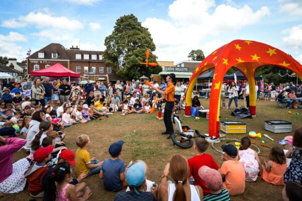 Crowd of people watching a man juggling