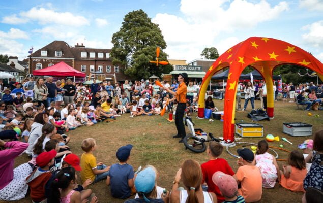 Crowd of people watching a man juggling