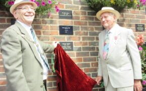 Two males unveil a plaque