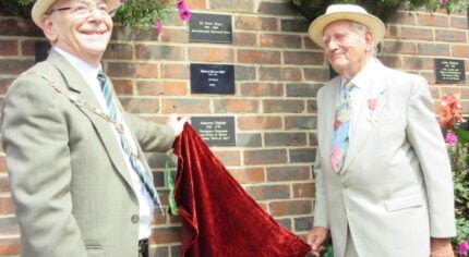 Two males unveil a plaque