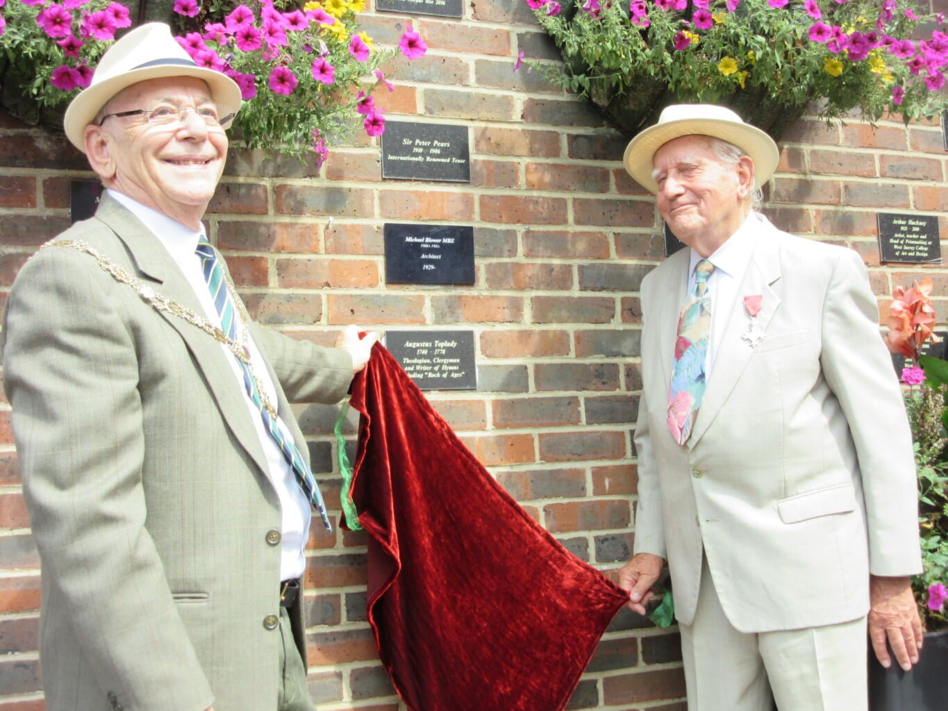 Two males unveil a plaque