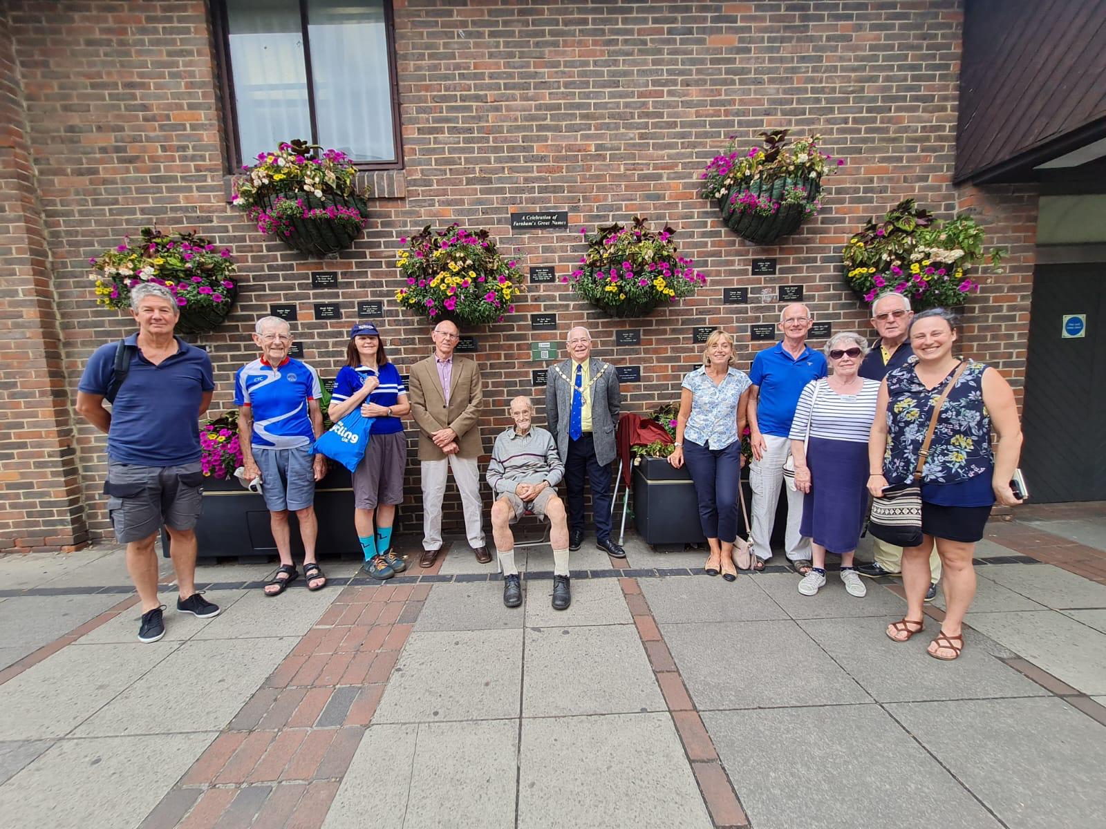 Group of people in front of wall displaying plaques