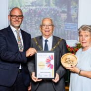 Three people holding a certificate