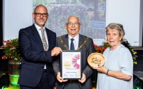 Three people holding a certificate