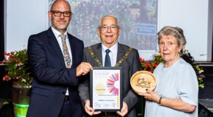 Three people holding a certificate