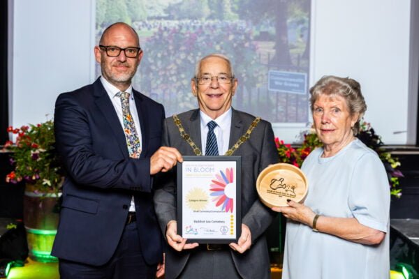 Three people holding a certificate