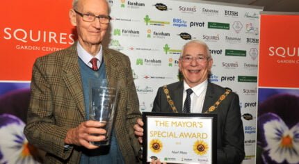 A male holding a glass vase standing next to the Mayor who is holding a certificate
