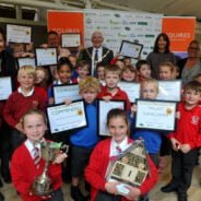 Group of school children holding certificates and trophies