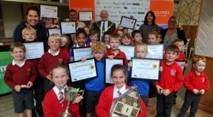 Group of school children holding certificates and trophies