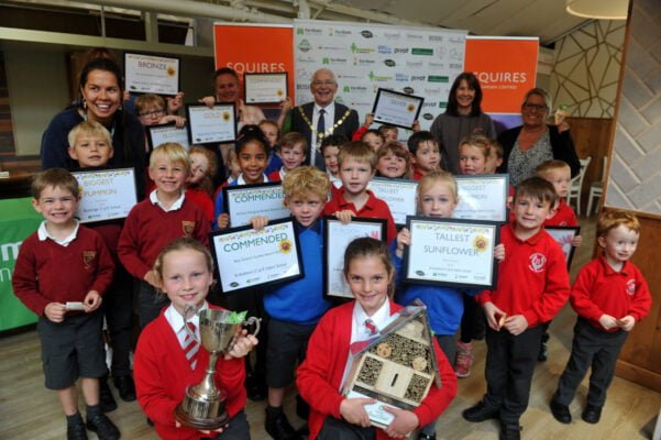 Group of school children holding certificates and trophies