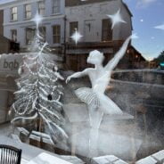 Snowy scene of a Christmas tree and ballerina on a shop window