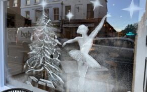 Snowy scene of a Christmas tree and ballerina on a shop window