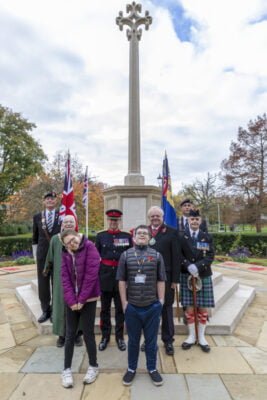 Young boy and girl with uniformed adults at war memorial