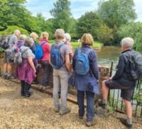 Group of walkers standing at the side of a river.