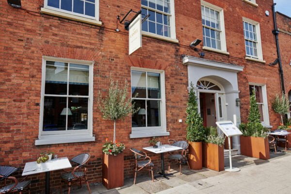 A photograph of the outside of the Castle public house on Castle Street, with tables and chairs and potted trees and plants