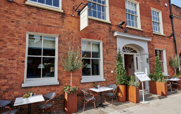 A photograph of the outside of the Castle public house on Castle Street, with tables and chairs and potted trees and plants