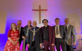 Group of musicians and the Mayor on stage.