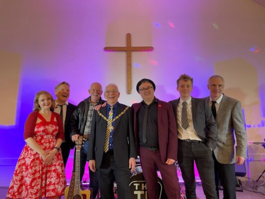 Group of musicians and the Mayor on stage.